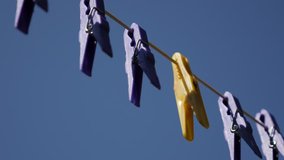 Shallow DOF colorful pegs in a row 4K 2160p 30fps UltraHD footage - Clothes line against blue sky 3840X2160 UHD video