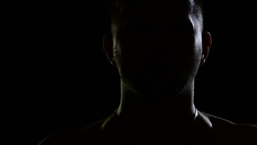 Man in the dark emotionally sings. Silhouettes of men, portrait in dark studio, shadows and lighting, head and hands. The singer sings song with emotion. Music video of unrecognizable young guy | Shutterstock HD Video #28820830