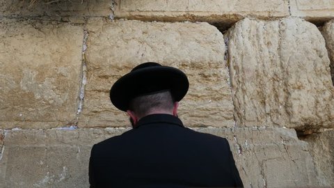Orthodox Hasidic Jew praying at Wailing Wall in Jerusalem (The Western Wall of Jerusalem.)