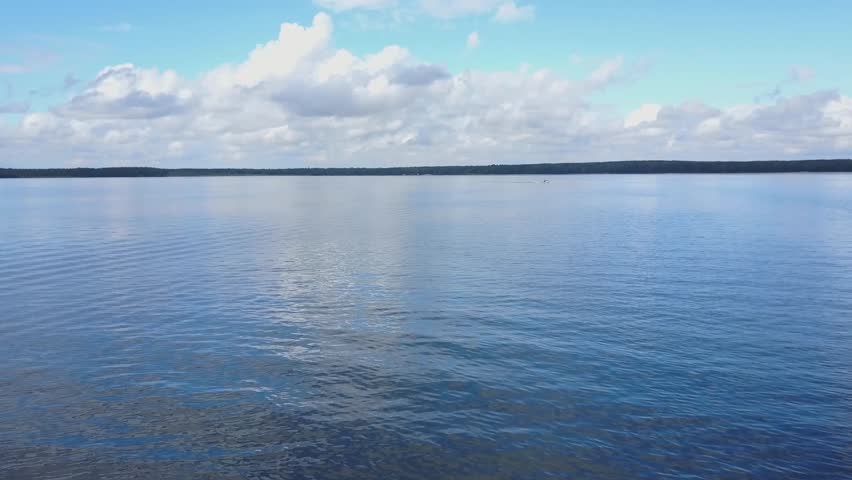 Morning on the calm lake with the reflection of the clouds and coastline in the water. Beautiful lake ladscape. Peacefull lake viev ladscape