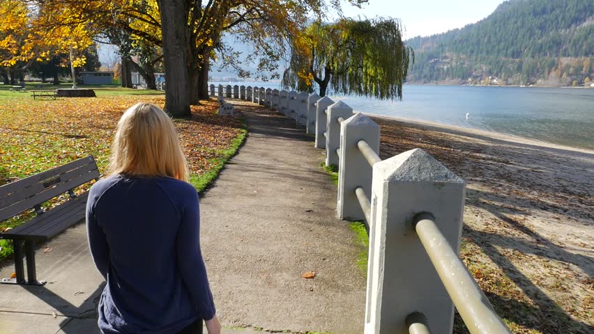 Female Walking Along Beautiful Nelson British Columbia Water Front Park On Kootenay Lake