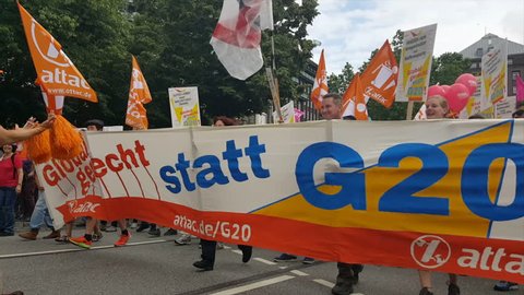 GERMANY - CIRCA JULY 2017 - G20 demonstration Hamburg 2017, demonstrators dance with banner, anti-war signs