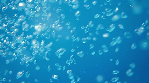 Bubbles rising to the surface. Slow motion. Air bubbles in clear blue water in pool (underwater shot), good for backgrounds.
