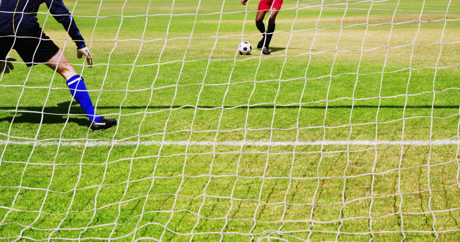 Goalkeeper misses a save in the field on a sunny day