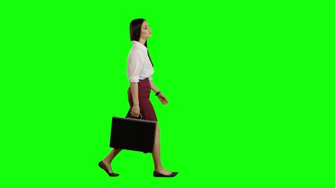Asian girl looks on the road holding a briefcase in her hands. Green screen
