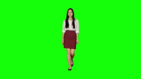 Girl walks and holds a phone and looks at photos. Green screen