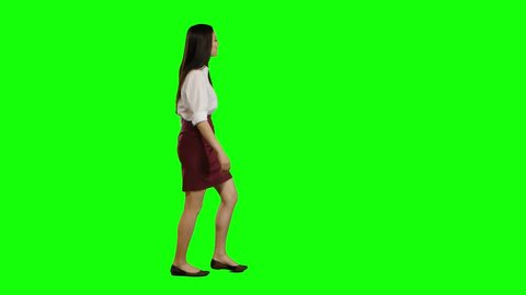 Girl of asian appearance goes to work and waves her hand. Green screen. Side view