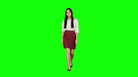 Girl of asian appearance goes to work and waves her hand. Green screen