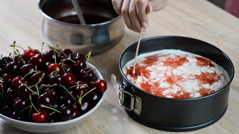 Making delicious and sweet cheesecake with cherry jelly
