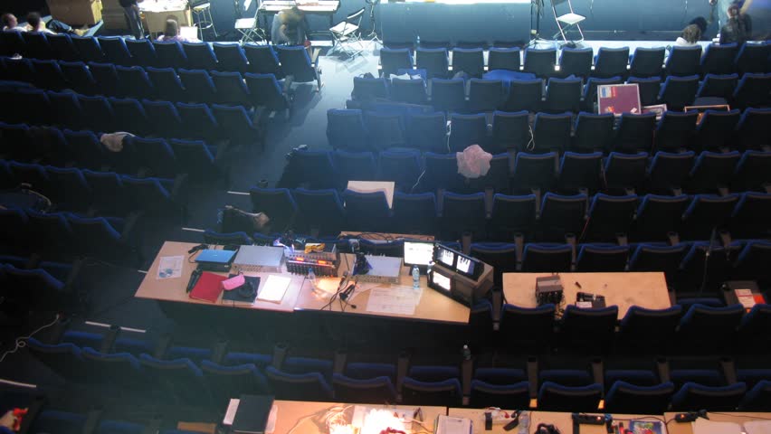 Dark blue chairs stand in spectator hall of theater, time lapse