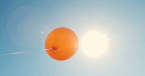 Balloon on a background of blue sky. a one balloon in the sky in a front of sun