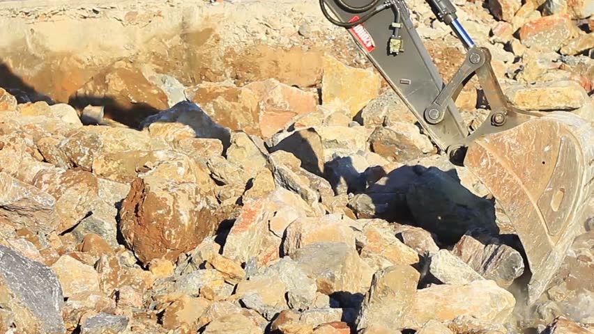 Excavator arm picks up the rocks