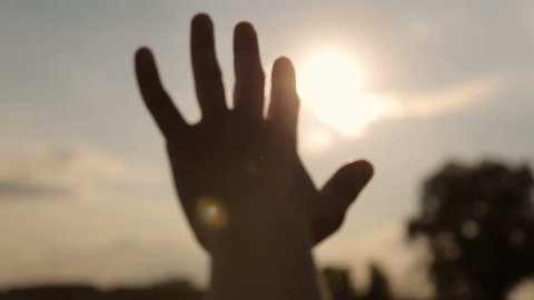 Glare of the evening sun through fingers