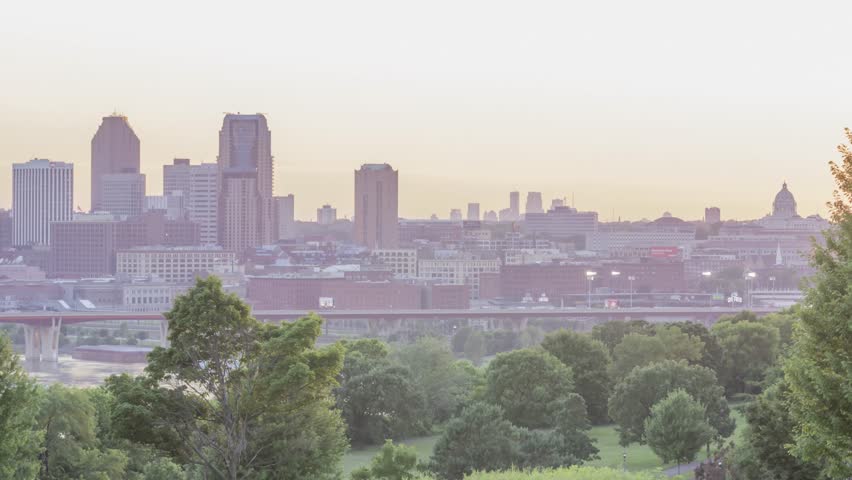A Medium Shot of Mounds Park in front of Downtown St Paul, Distant Minneapolis Skyscrapers, and the Minnesota State Capitol Awash in Orange Sunset Light 4K UHD Timelapse