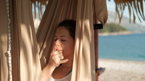 Woman in a hammock on the beach yoga breathing alternate breathing