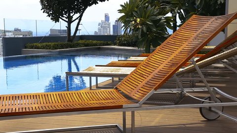 wooden teak Lounge Chairs, Patio Furniture, at Poolside with garden background