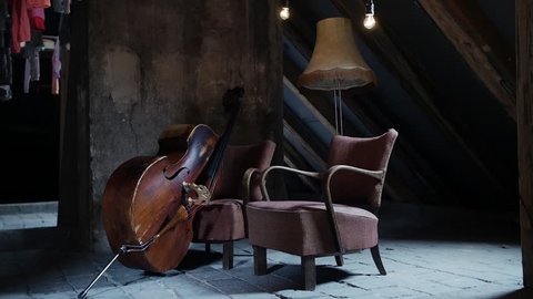 Old bass in a composition with vintage chairs situated in old baroque attic
