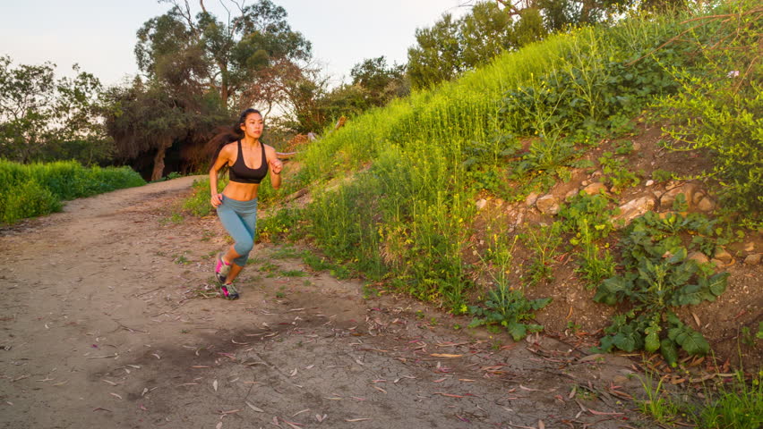 Athletic woman trail running in the hills surrounding Los Angeles.