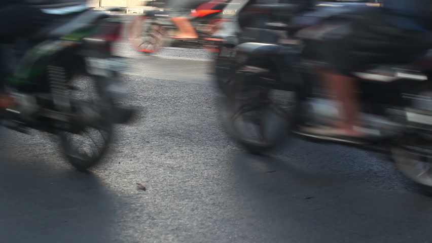 Casual day in city: motorcycles, cars driving on road