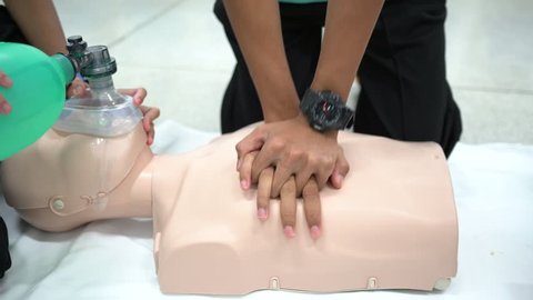 Nursing students are learning how to rescue the patients in emergency. CPR training with CPR doll and Ambu Bag.Closed-up of hand. Dolly shot.