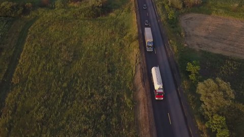Aerial footage of trucks and cars on the road in summer sunset