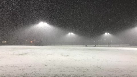 West Virginia, United States - May 20, 2017: Snow flakes at night on iluminated field