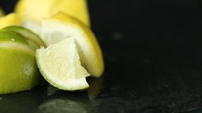 Close-up of woman hand cutting lemon on black stone