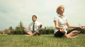 Young business people relaxing outdoors in lotus pose after long working hours