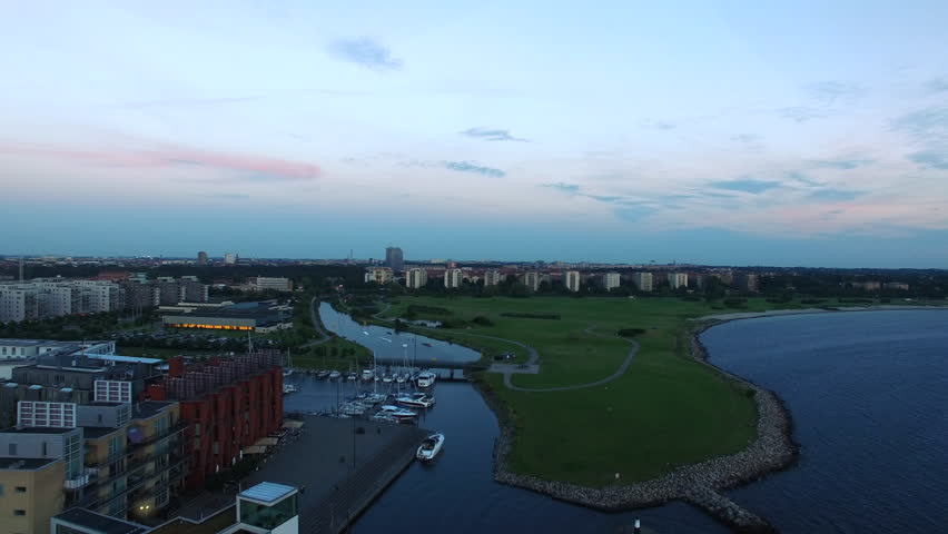 Aerial view of Malmo city by the sea at dusk. Marina harbor, coast and field