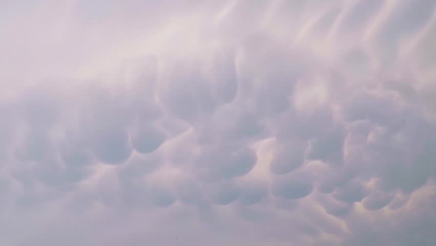 POV of sky background with unusual configuration clouds in sunset. Camera moving.
