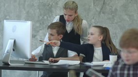 Three little children in business suits sitting at table with laptop, discussing something