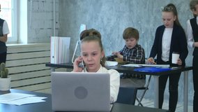 The kids discuss project in office, while one business girl talking on phone