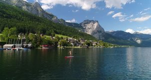 Beautiful woman in Bikini on a Stand Up Paddle Board on Lake Grundlsee in the middle of the Austrian Alps.