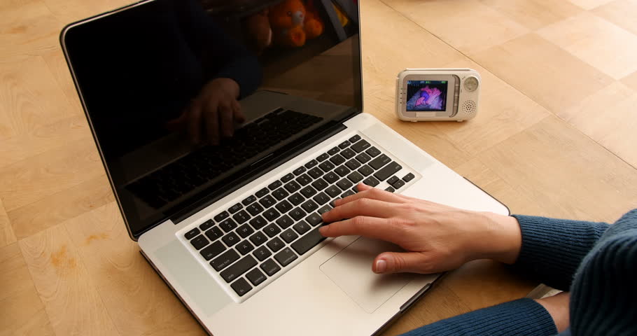 Woman sitting at kitchen table using laptop at home