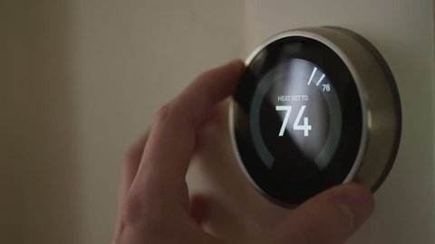 Man Adjusting Smart Thermostat Gadget Settings At Home