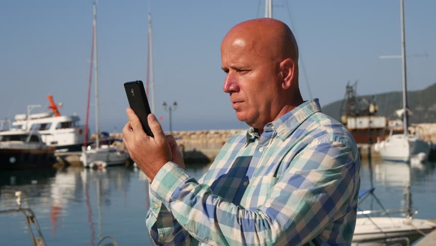 Satisfied Tourist Smile and Take Pictures in a Harbor Using Personal Cellphone (Ultra High Definition, UltraHD, Ultra HD, UHD, 4K, 3840x2160)