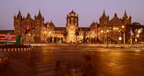 Day to night time lapse shot of traffic moving in front of Chhtrapati Shivaji Terminus (CST) formerly known as Victoria Terminus (VT) is being lit up as the night approaches, Mumbai, India