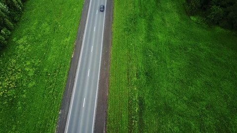 Delivery trucks driving towards the sun. Aerial view 0f green fields and trucks