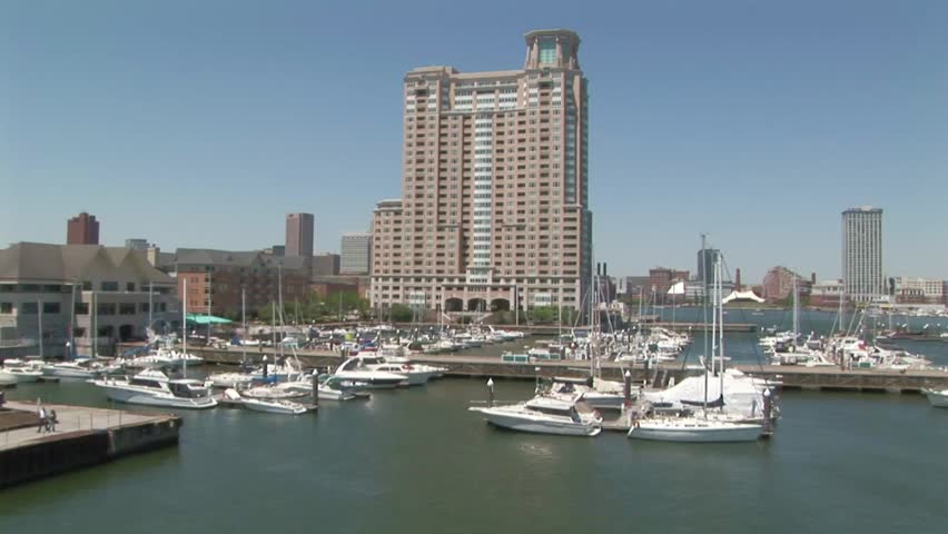 Inner harbor with docked boats with commercial building in background, Baltimore Maryland USA