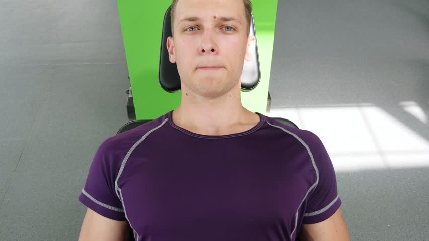 Attractive Young Man Doing Leg Press On Machine In Gym.