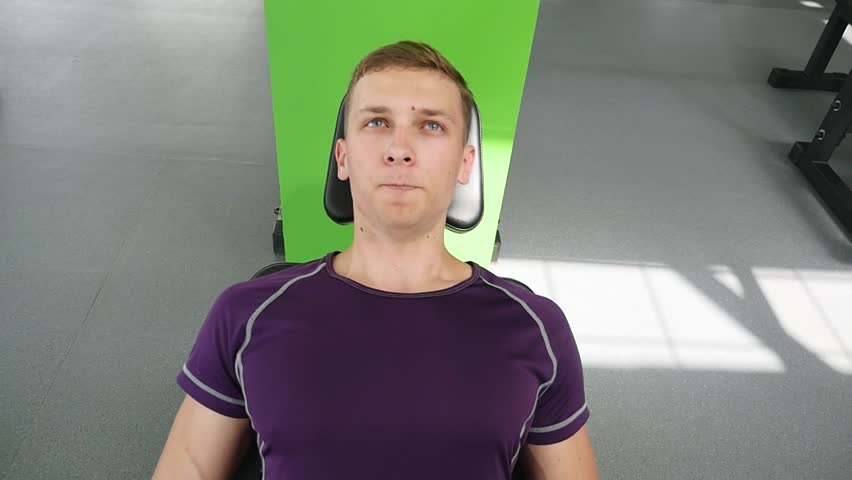 Attractive Young Man Doing Leg Press On Machine In Gym.