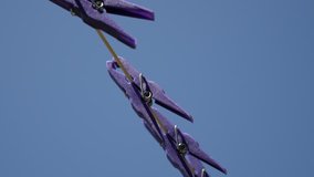Blue sky and plastic clothespins in a row 3840X2160 UHD video - Purple pegs on laundry drying line 2160p 30fps UltraHD footage