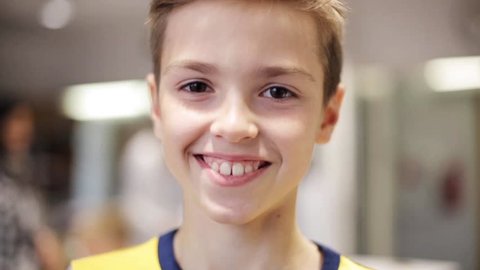 education, childhood, emotion, expression and people concept - happy smiling preteen boy face at school classroom