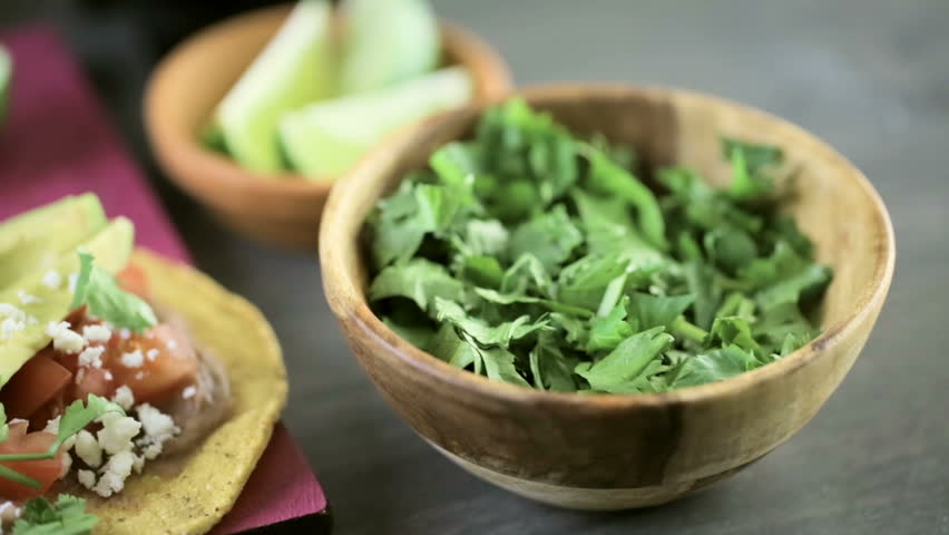 Fresh vegetarian Mexican tostadas on purple cutting board.