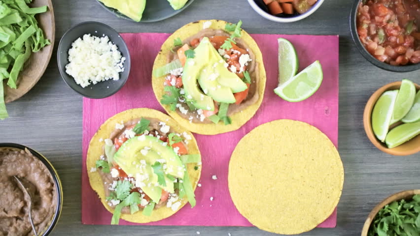 Step by step. Fresh vegetarian Mexican tostadas on purple cutting board.