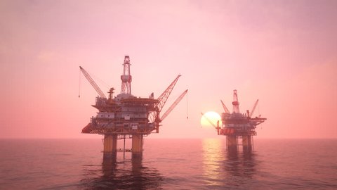 Two offshore platforms or oil rigs at sunset pink sky