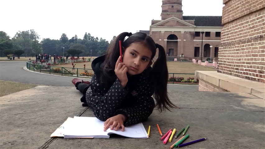 Little school girl thinking outside her school campus.