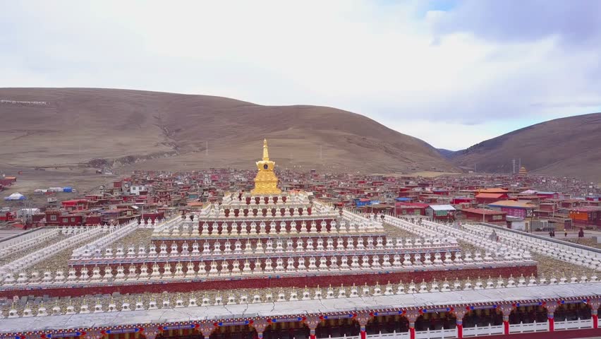 Aerial view of the pagodas with buddhist monks walking under at Yarchen Gar Monastery In Sichuan, China