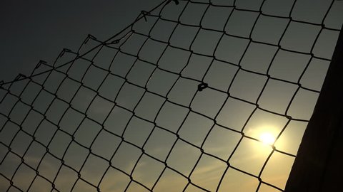 Silhouette of desperate woman imprisoned behind a net