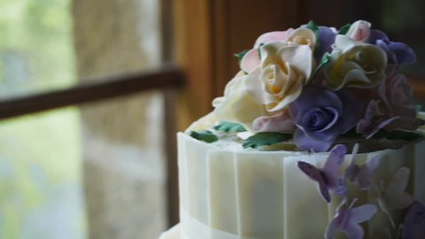 a close up dolly shot of a beautifully decorated wedding cake